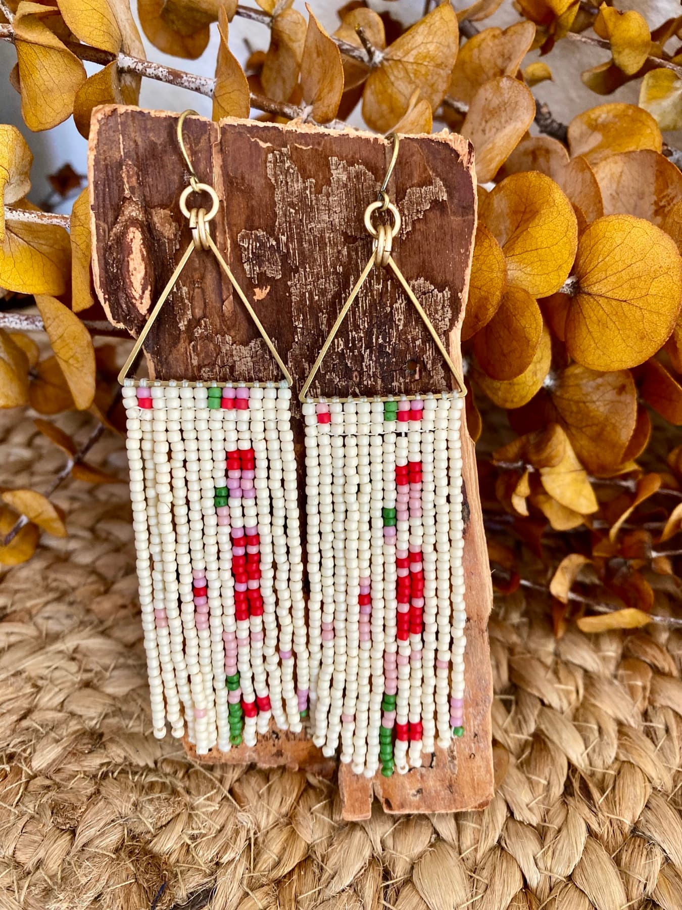 Cream fringe earrings with a pink and green floral bead pattern
