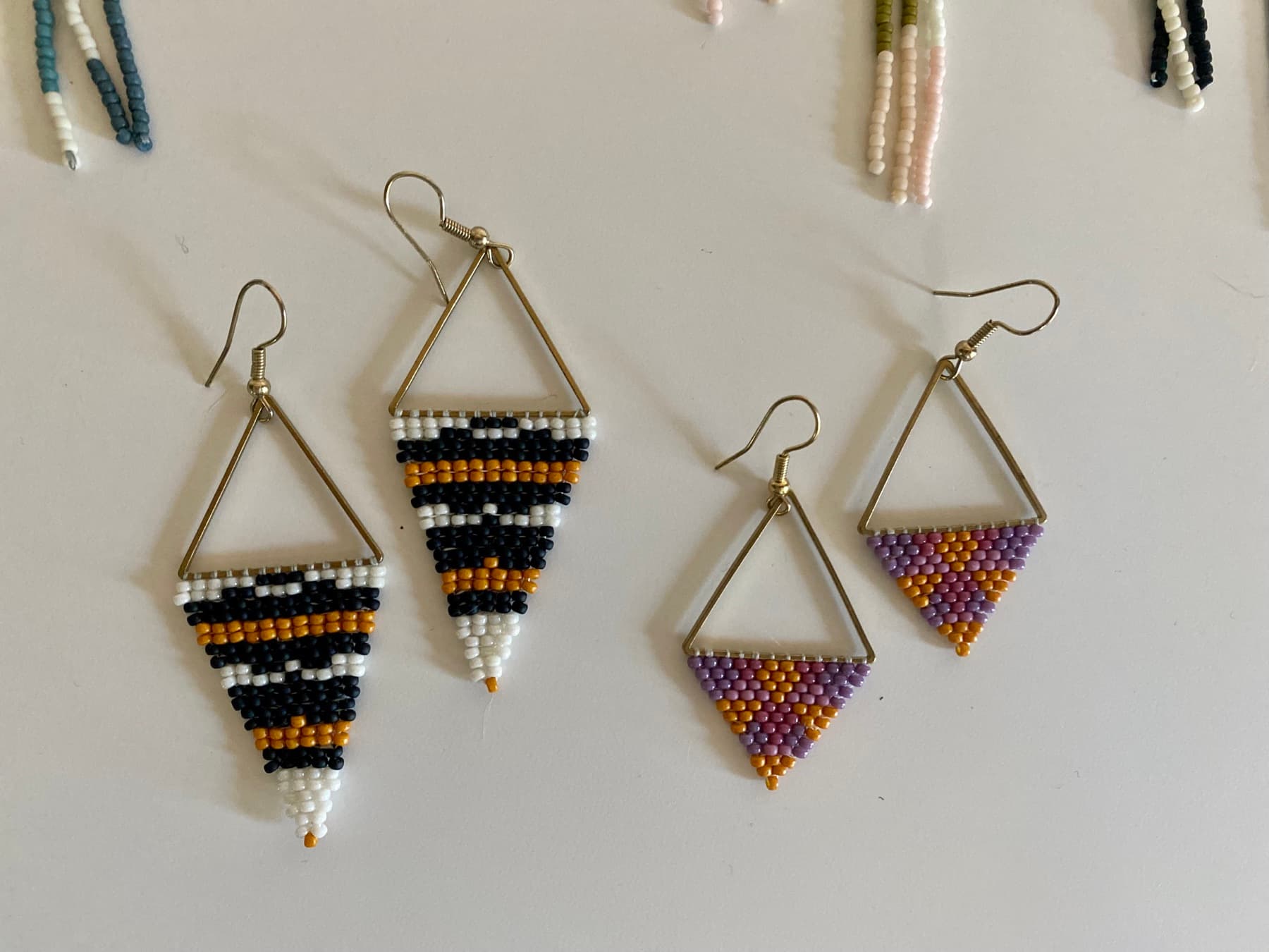 Two pairs of small geometric hand-beaded earrings